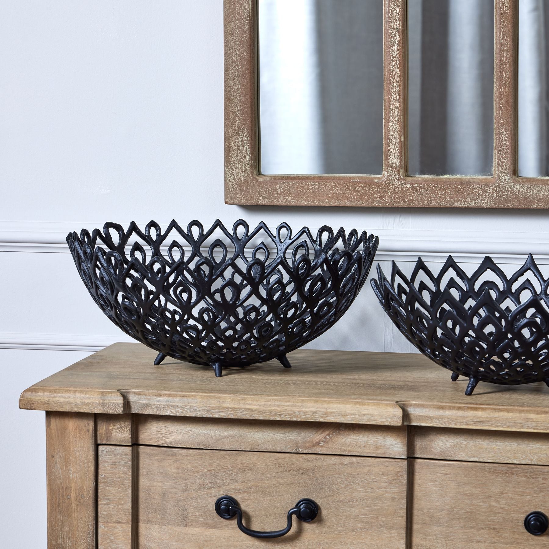 Teesh Lattice Bowl in matt black aluminum with intricate perforated patterns on wooden table.