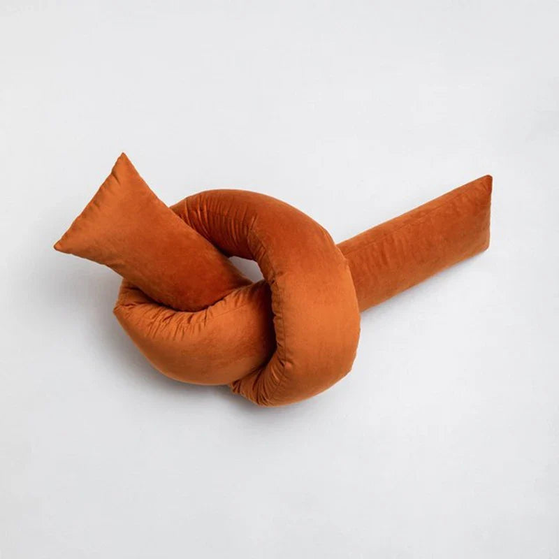 Orange Cyril Cushion with a unique knot design for playful children's room décor.