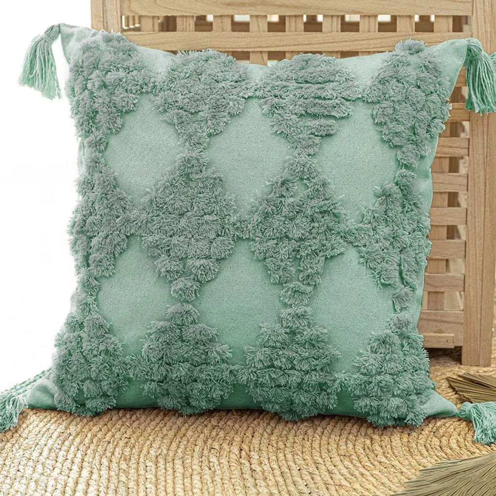 Moroccon style pillow case with intricate patterns and teal tassels.