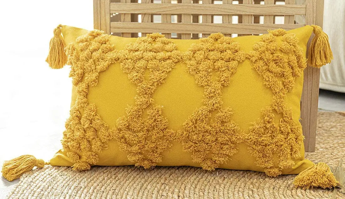 Moroccan style yellow pillow case with intricate patterns and tassels.