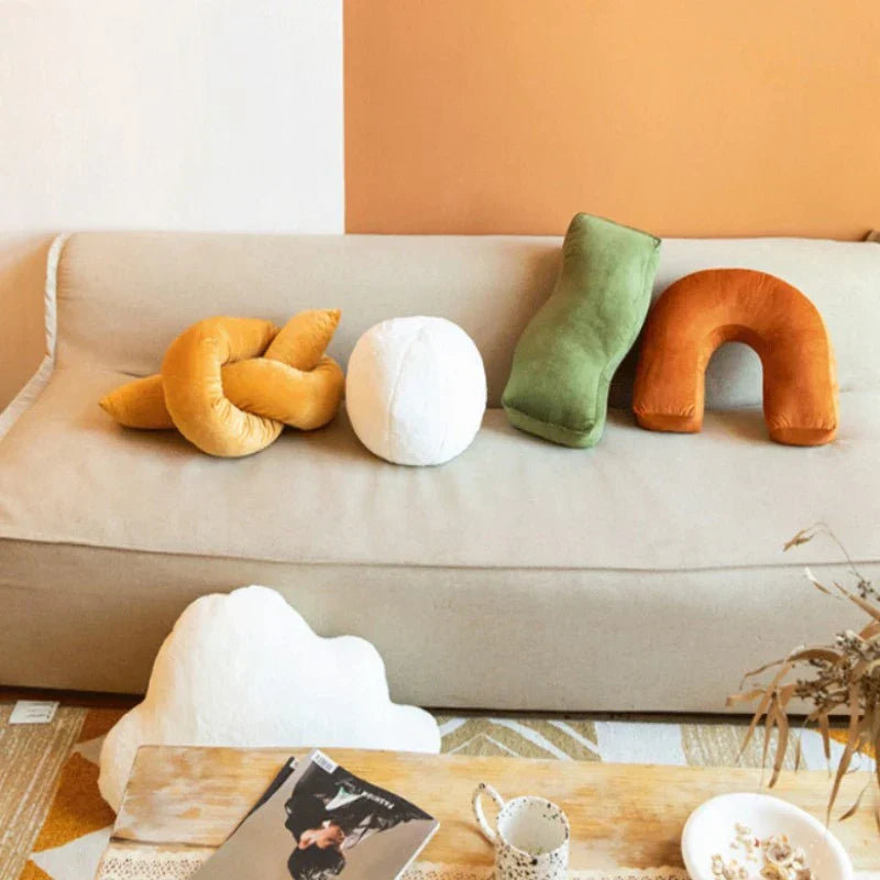 Playful Cyril Cushions with unique waves and knot design on a beige sofa.