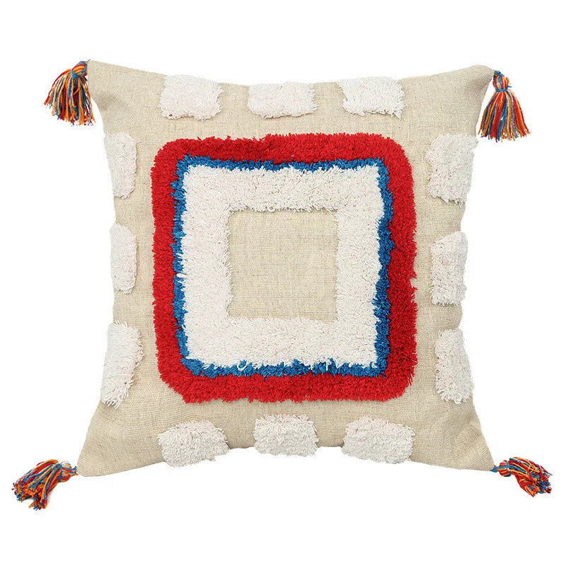 Moroccon style pillow case with intricate patterns and tassels.