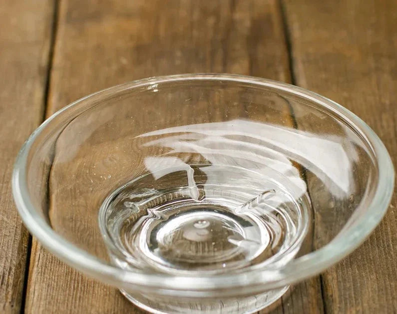 Vishka glass soap dish on wooden surface, featuring easy-to-clean design for a clutter-free bathroom.