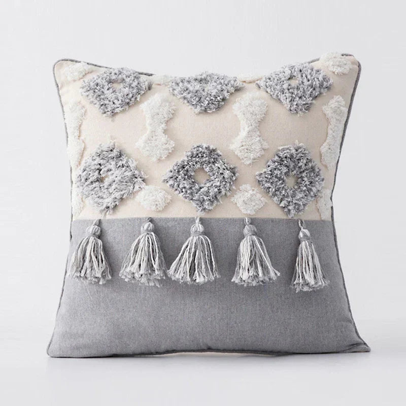 Moroccon style pillow case with intricate designs and tassels.