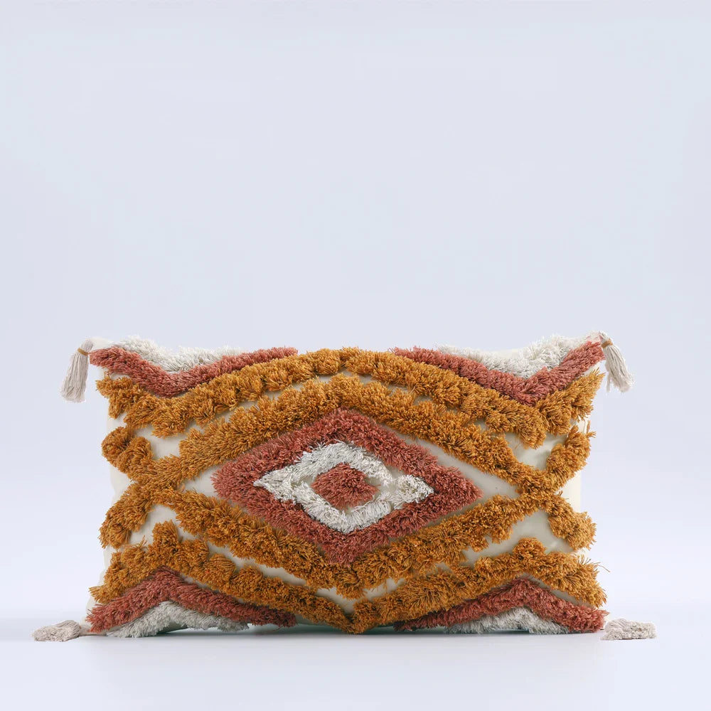 Moroccon style pillow case with intricate patterns and tassels.