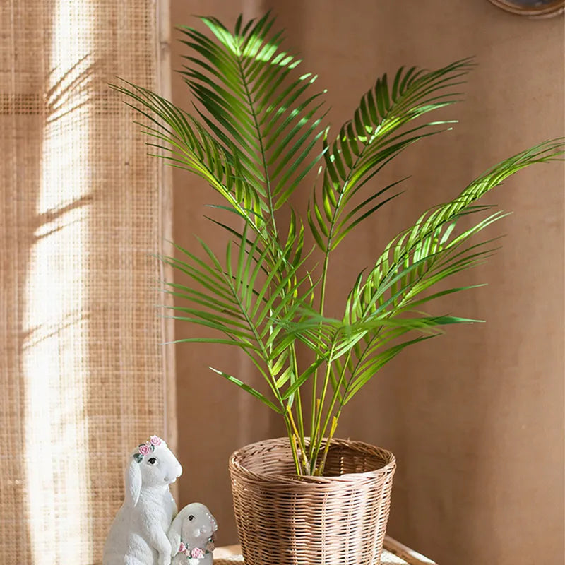 Faux palm tree branch in wicker basket decor for home.