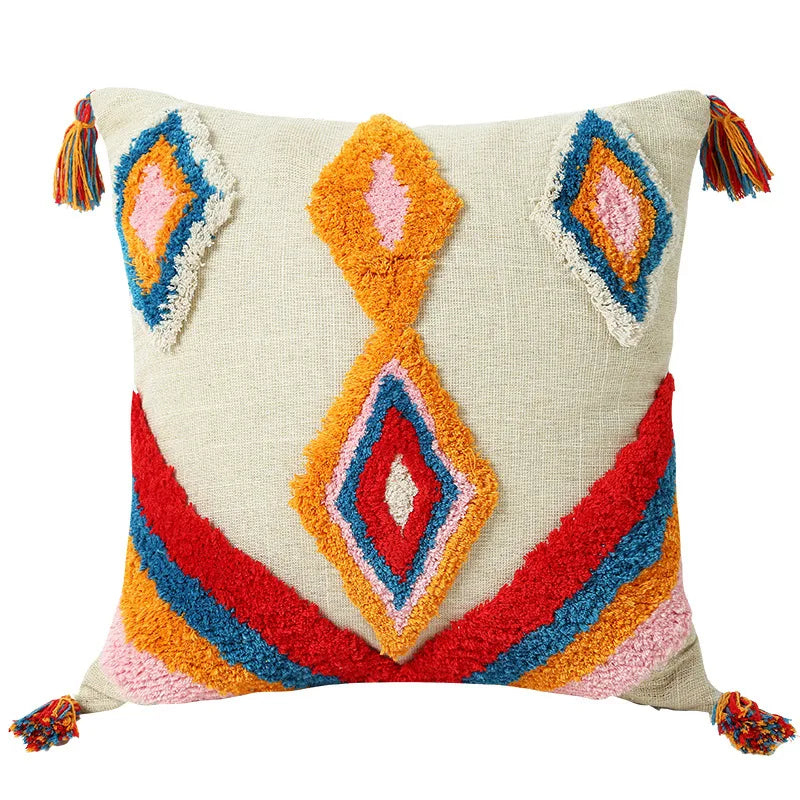 Moroccon style pillow case with colorful geometric patterns and tassels.