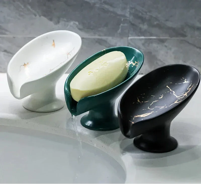 Ceramic soap dish set with white, green, and black designs, holding a bar of soap.