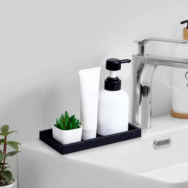Silicone soap dispenser tray on bathroom sink holding lotion, soap, and a plant.