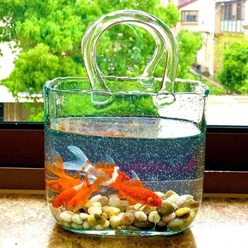 Glass tote bag-shaped vase with fish and pebbles, unique home decor.