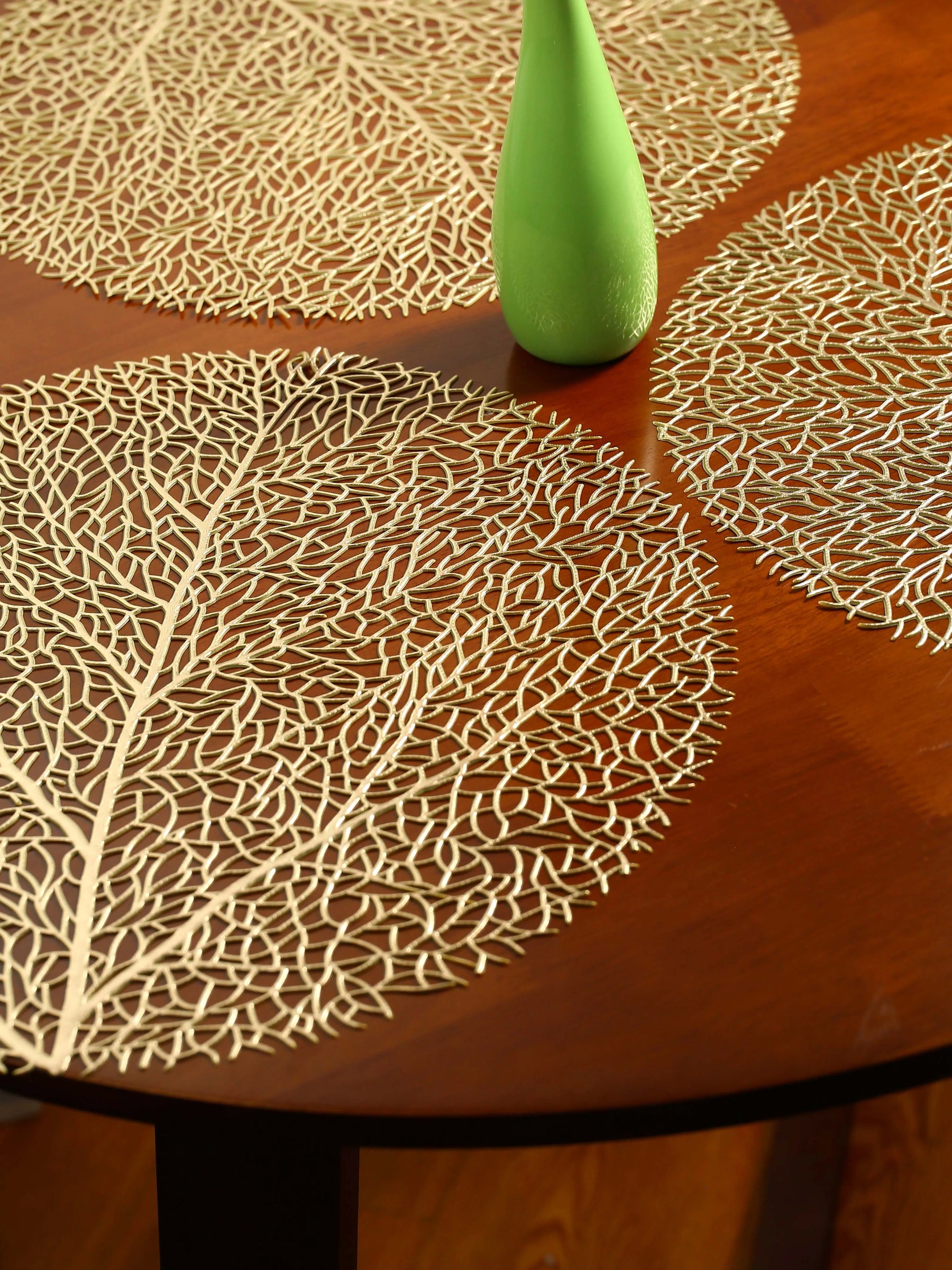 Ollie Placemats set of 4 in gold leaf design on wooden table.