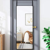 Full length door hanging mirror with metal frame in room setting.