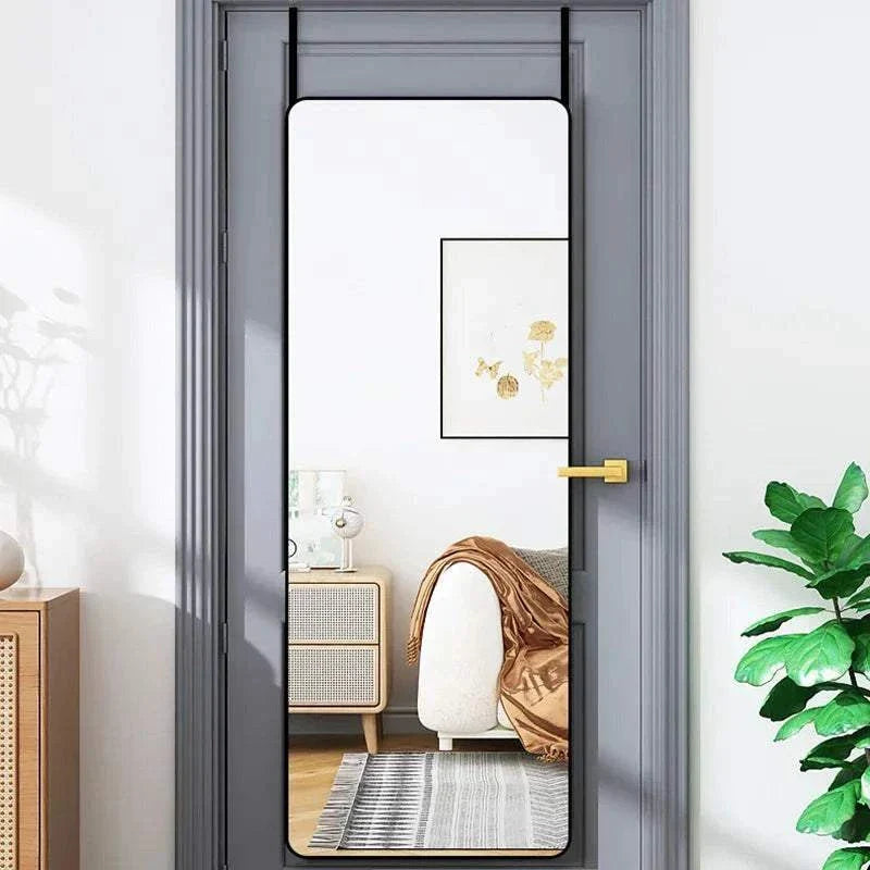 Full length door hanging mirror with metal frame in room setting.