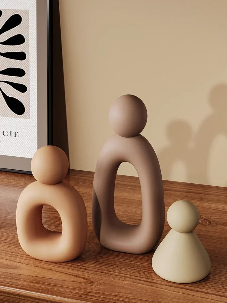 Minimalism Family Statue with neutral colors on a wooden surface.