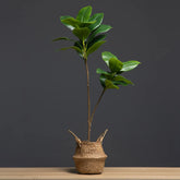 Faux Magnolia Tree Branch in woven basket, showcasing realistic greenery for home decor.