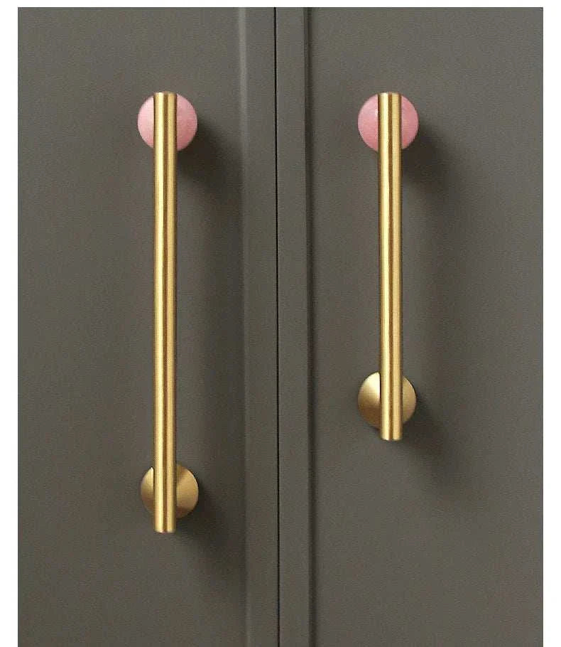 Natural crystal and brass furniture handles on dark cupboard.