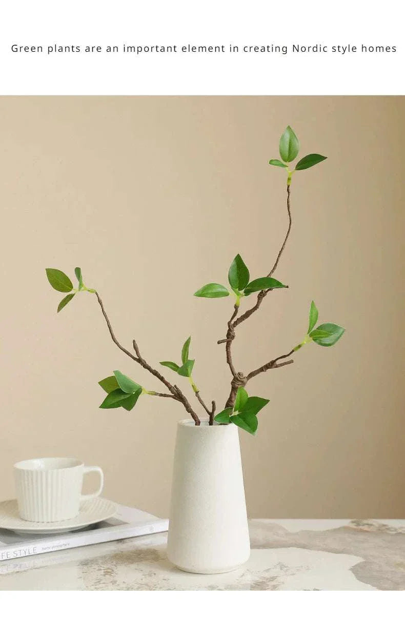 Artificial withered branches in a white vase, showcasing realistic textures and tender buds, ideal for home decor.