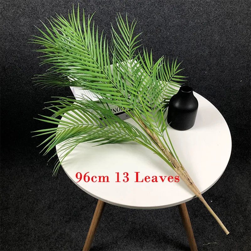 Faux palm tree branch with 13 leaves on a round table.