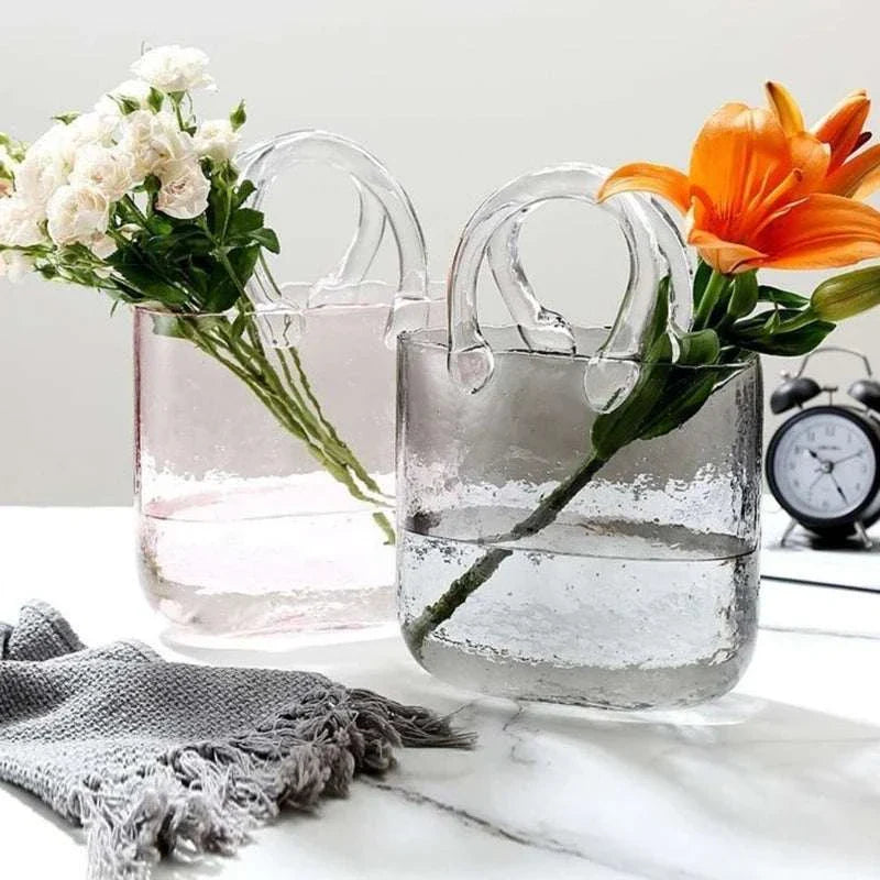 Glass vase shaped like a tote bag with flowers, adding a modern twist to home decor.
