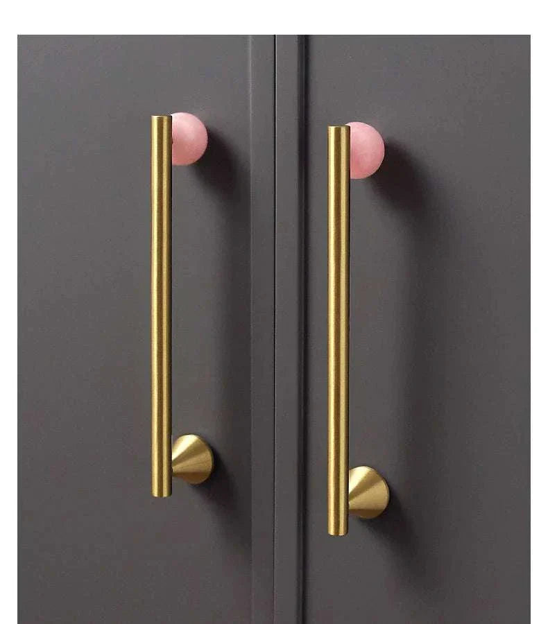 Natural crystal and brass furniture handles on dark cabinets.