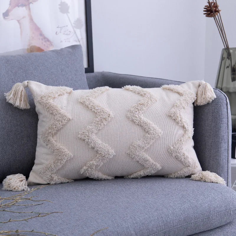 Moroccon style pillowcase with intricate cream patterns on a sofa.