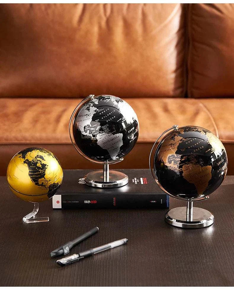 Aya Globes in black, bronze, and gold on a table, enhancing home or office decor.