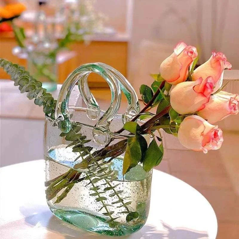 Glass vase shaped like a tote bag with flowers, offering a modern twist to traditional designs.
