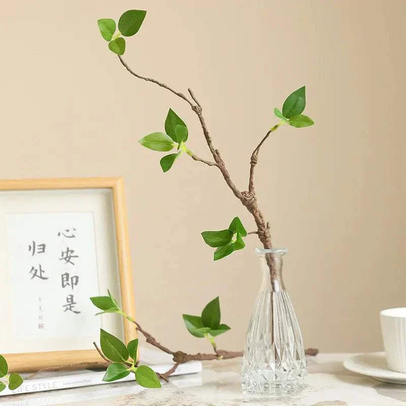 Artificial withered branches with tender buds in a clear vase, creating a natural ambiance for home decor.