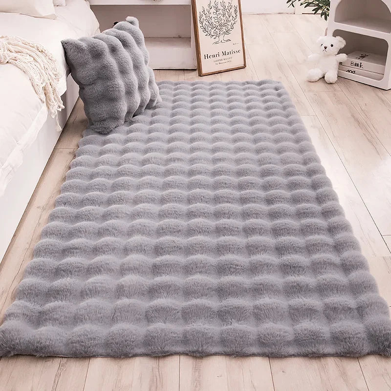 Soft gray Adjoa Rug made from 100% polyester, showcasing luxurious texture in a cozy home setting.