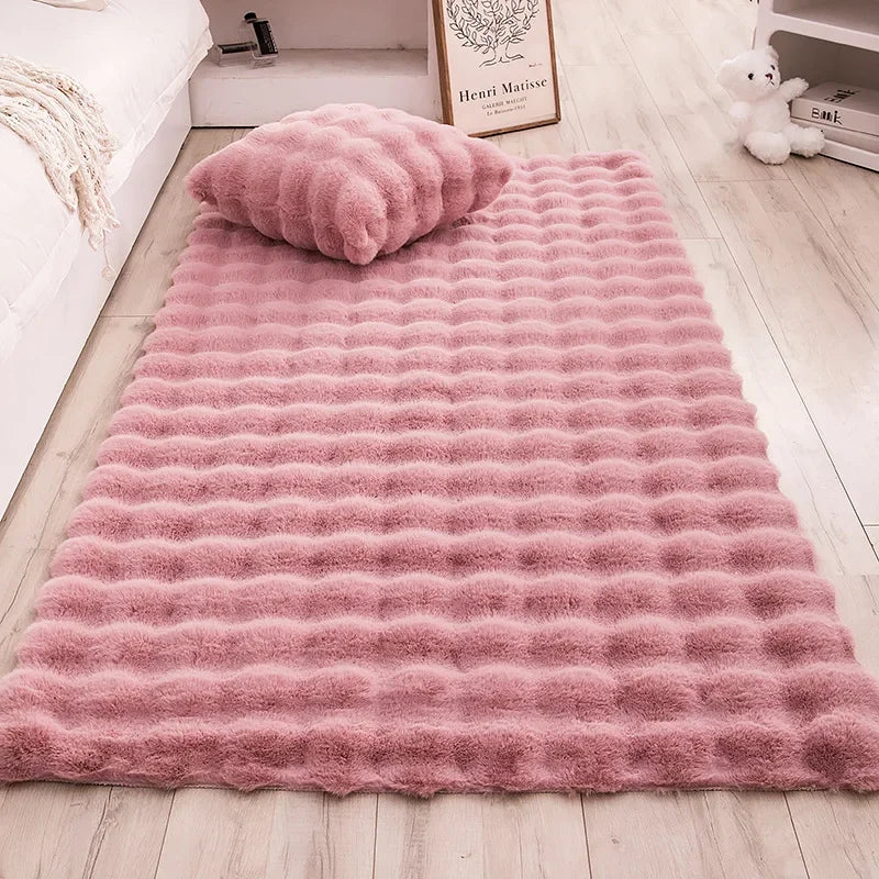 Adjoa Rugs in pink, made from soft and durable 100% polyester, displayed with a matching pillow.