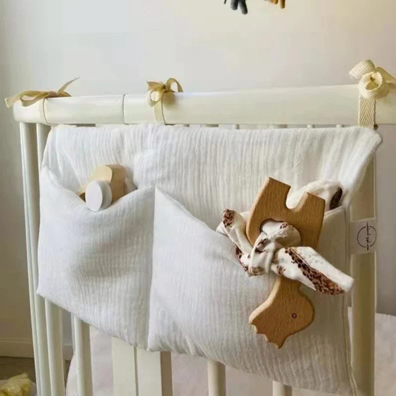 Arian Baby Crib Storage Bag hanging on crib with pockets for essentials.