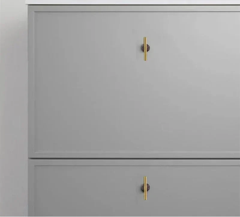 Natural Crystal pink cabinet knobs with brass, enhancing gray kitchen cupboards.