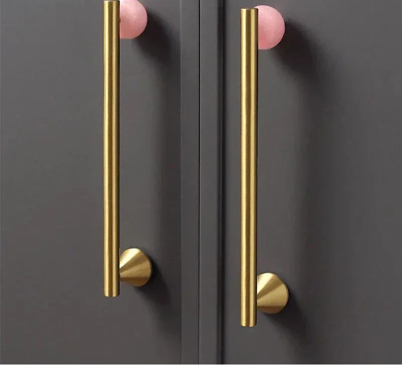 Natural crystal and brass furniture handles on dark cupboard.