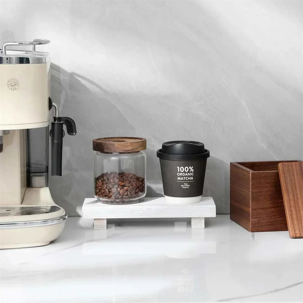Small Wood Riser elevating coffee items next to a cream espresso machine on a white counter.
