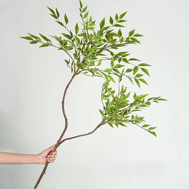 Alexis Faux Palm Tree Branch, realistic faux plant held in hand against a light background.