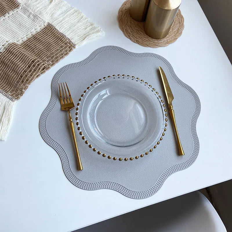 Noah's Placemats in elegant design with glass plate and gold cutlery on a dining table.