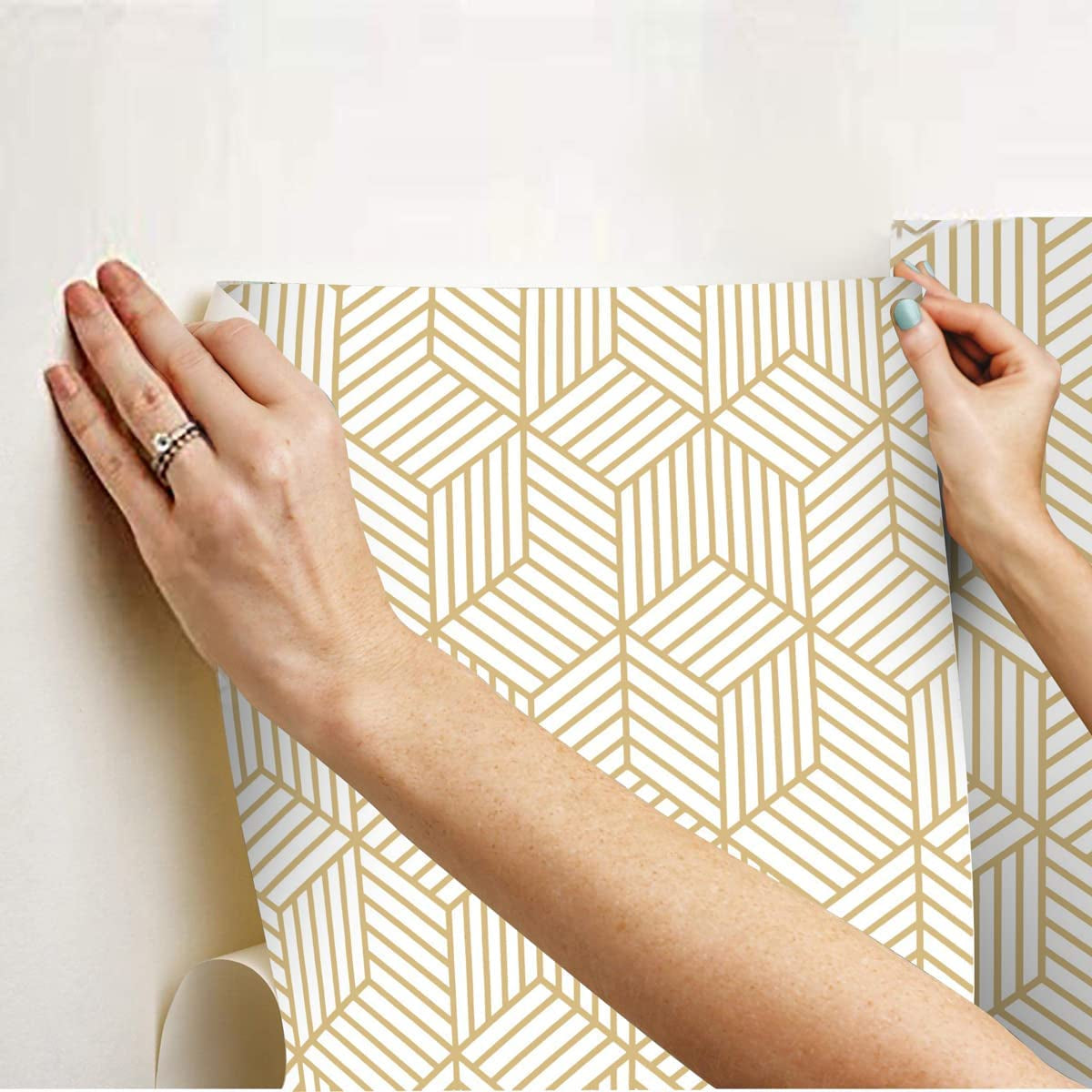 Geometric hexagon wallpaper being applied to a wall.
