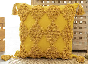 Moroccan style pillow case with intricate patterns and tassels in warm tones.