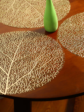Ollie Placemats set of 4 in gold leaf design on wooden table.