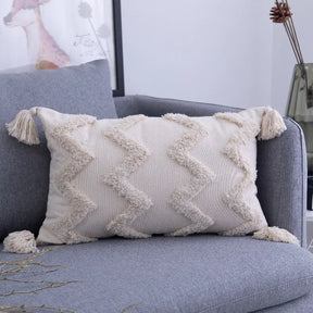 Moroccon style pillowcase with intricate cream patterns on a sofa.
