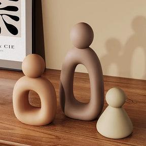 Minimalism Family Statue with neutral color palette on wooden surface.