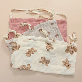 Arian Baby Crib Storage Bag in soft cotton with teddy bear and rainbow designs, hanging for easy nursery organization.