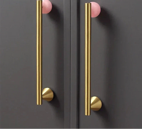 Natural crystal and brass furniture handles on dark cupboard.